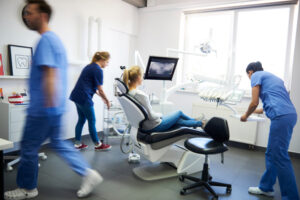 team of dentists scrambling in an emergency dental situation