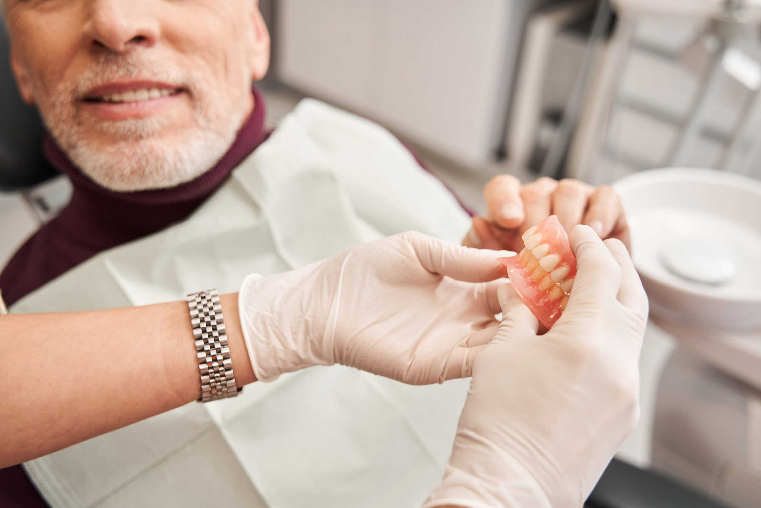 doctor showing a pair of dentures to a patient in Yuma, AZ